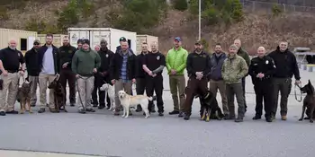 Handlers and their dogs standing outside
