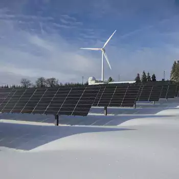 solar panels with a wind turbine in the background