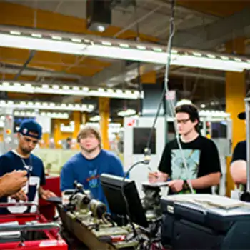 Machine shop students being lectured by their teacher