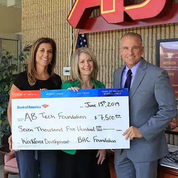 Three people holding a oversized check to the A-B Tech Foundation
