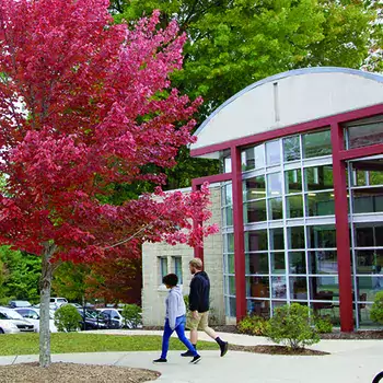 Two students walking in front of Student Services/Bailey Building in the Fall.