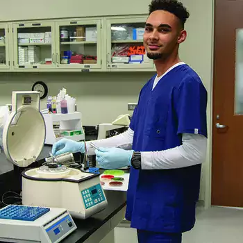 Medical student in a lab wearing scrubs