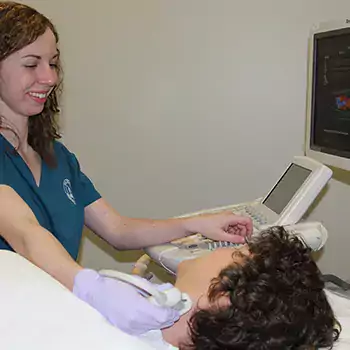 Sonography student with machine checking patients vein