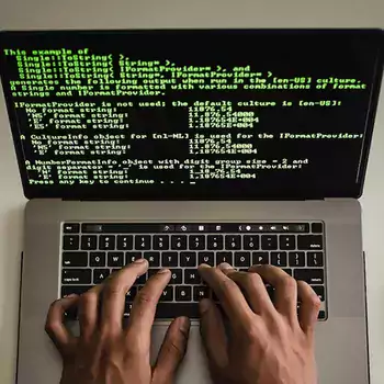 Hands typing on a laptop