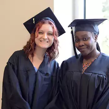 Two people wearing a graduation cap and gown