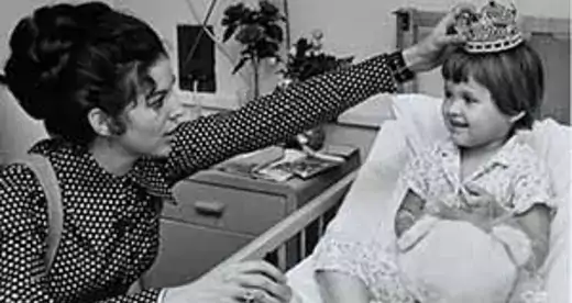 Connie Learner, the first Jewish Miss North Carolina in 1970, places a tiara on a young girl's head.