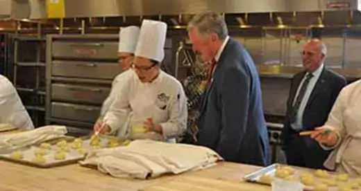 Mark Meadows at counter talking to a  Baking and Pastry Arts student
