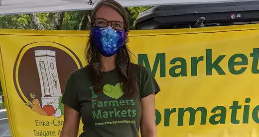 Woman wearing a mask in farmers market booth 