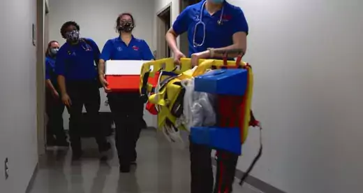 EMS students with equipment in a hallway