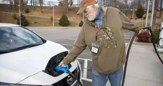 Man putting charger on electric car