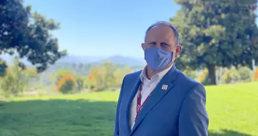 Dr. John Gossett standing outside wearing a blue face mask