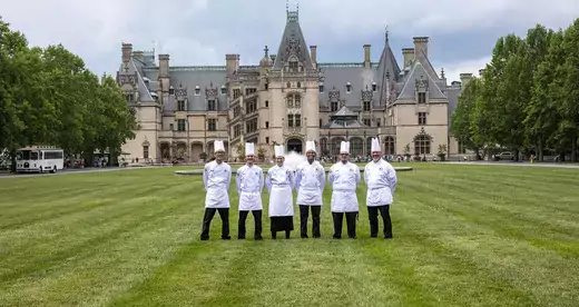 six chefs standing on a lawn in front of the Biltmore House