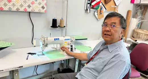 Job Preparedness: Johnny Ko teaches industrial sewing classes at the A-B Tech satellite campus at Asheville Buncombe Community Christian Ministry. Ko demonstrates how to use a single needle Juki industrial sewing machine in a classroom. Photo by Jessica Wakeman