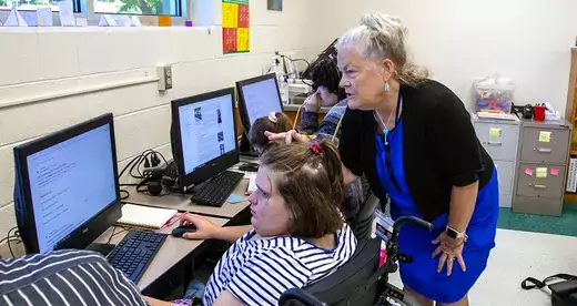 SOAR teacher helping a student at a computer