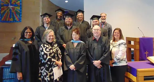 A group of Craggy graduates standing on stairs