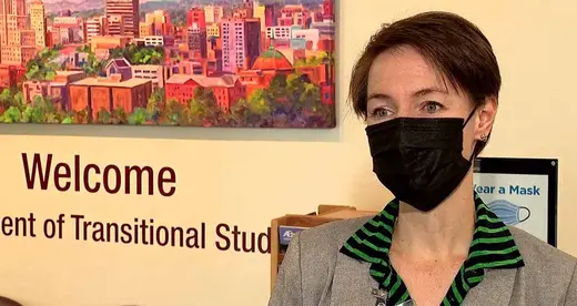 Woman in face mask standing in front of a wall