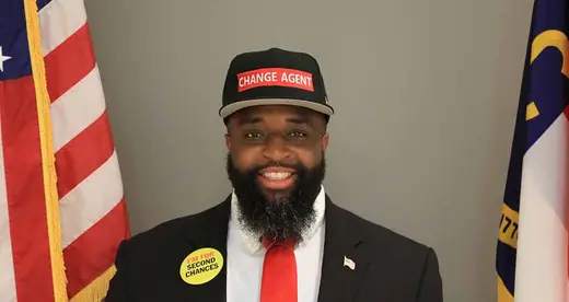Philip Cooper standing between two flags