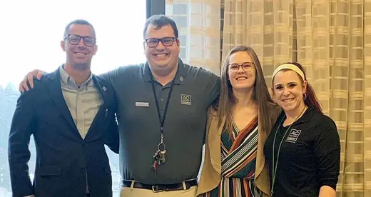 Two men and two women standing in a row