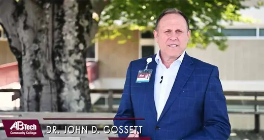 John Gossett standing on a deck in front of a tree