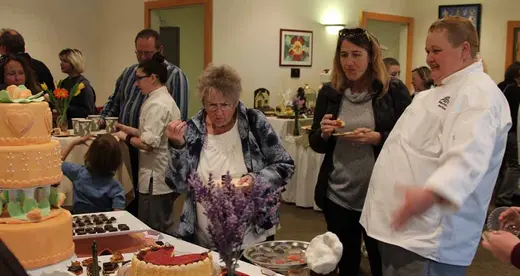 Baking chef at table with two women 