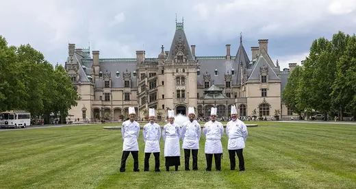 six chefs standing on a lawn in front of the Biltmore House