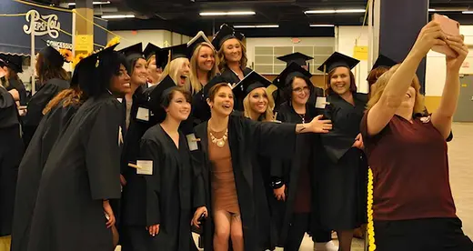 Students taking group selfie at commencement