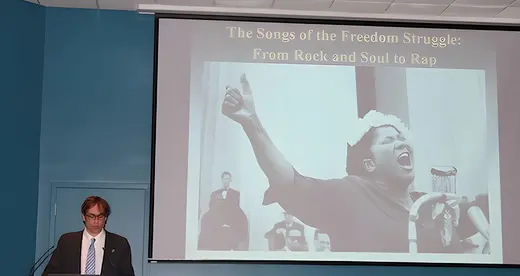 David Gilbert standing in front of a screen