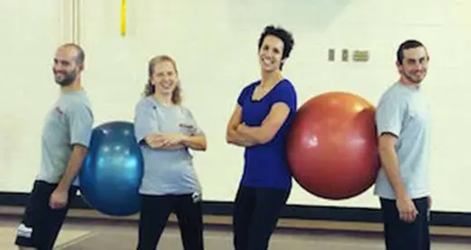 Four people with two large playground balls