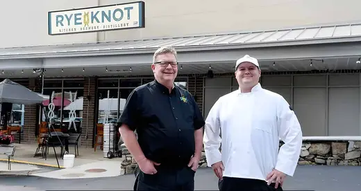 Man and chef in front of distillery