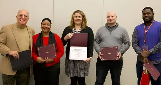 Five people holding RISE awards