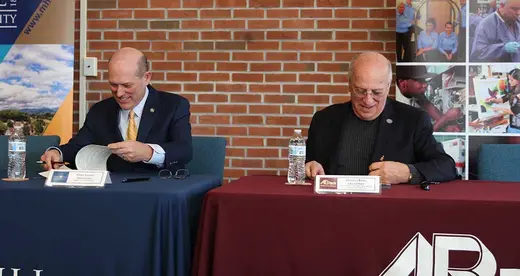 Dennis King and Tony Floyd signing a document