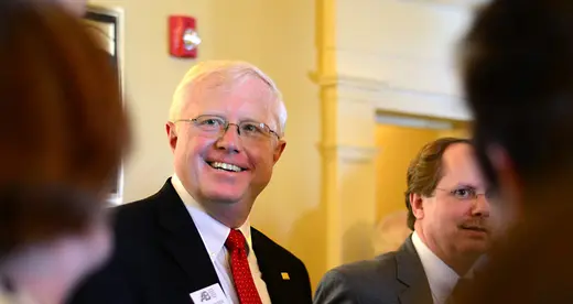Two men standing next to yellow wall