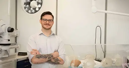 Man in white shirt standing in a simulated hospital environment