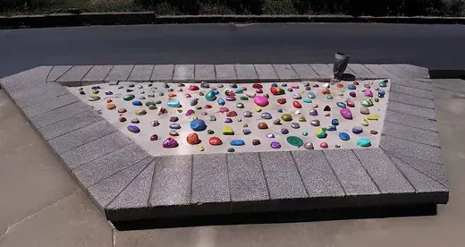 Rocks with positive messages laid in sand pit.