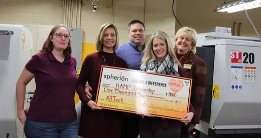 Five people with a giant check