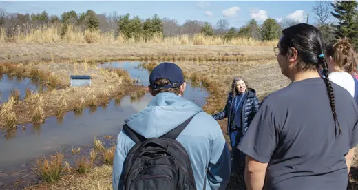 Helen Burrell and students at retention pond