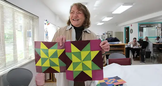 Marilyn Hoffman holding a quilt