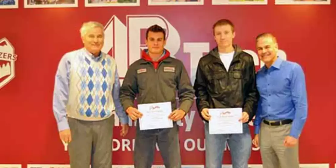 Gentry Heating President and three Gentry Heating Scholarship recipients standing in front of a wall