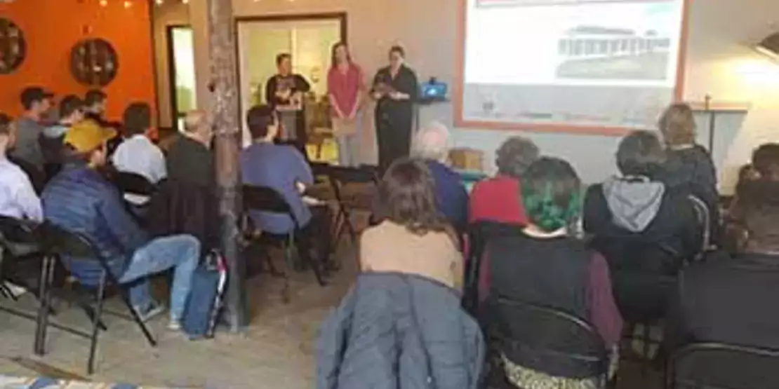 Students Nora Steppe, Jennifer Webb and Farra Lomasney standing in front of an audience.