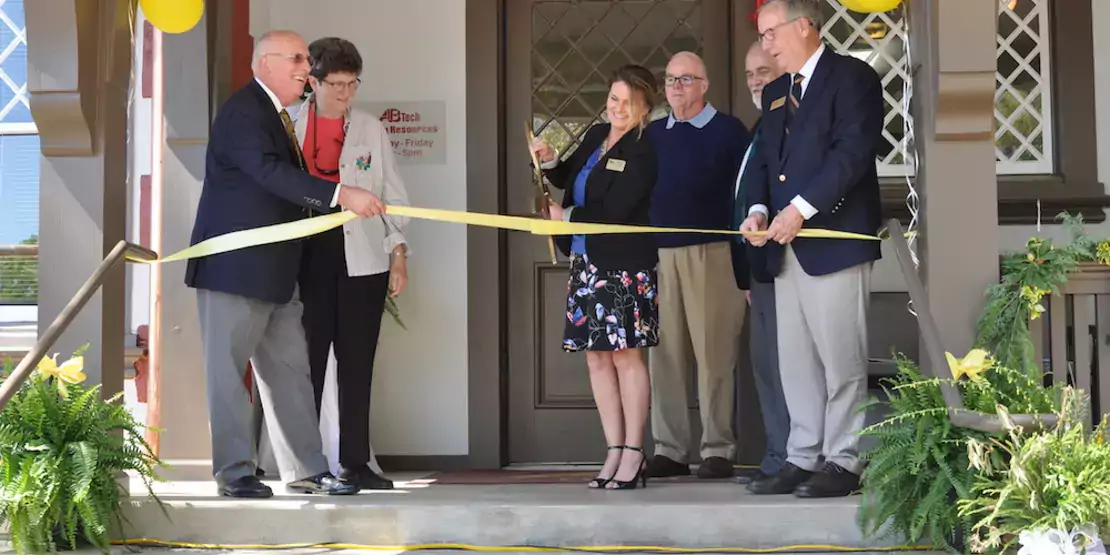 Six people at a ribbon cutting on Sunnicrest porch