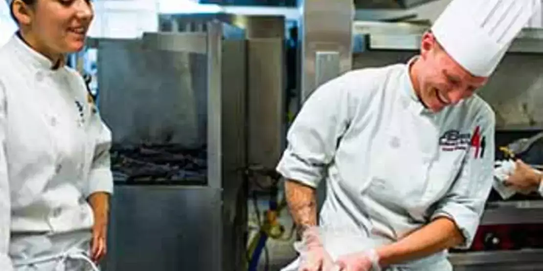 Culinary students preparing food on a counter.