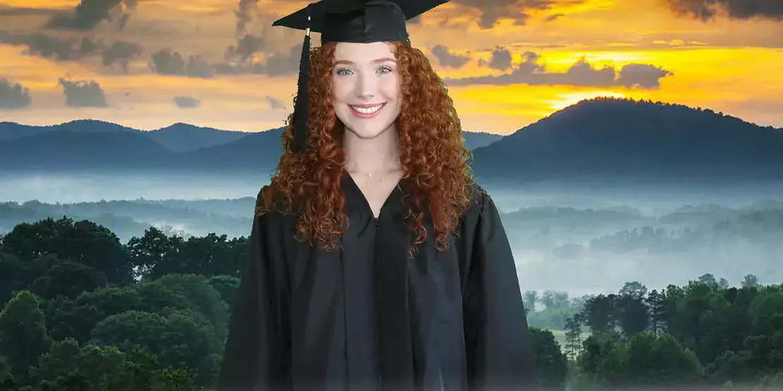 Woman in cap and gown in front of mountains