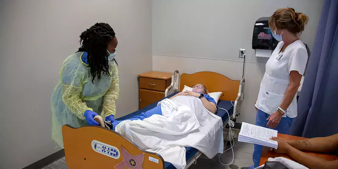 Nurse Aide (CNS) student assisting patient