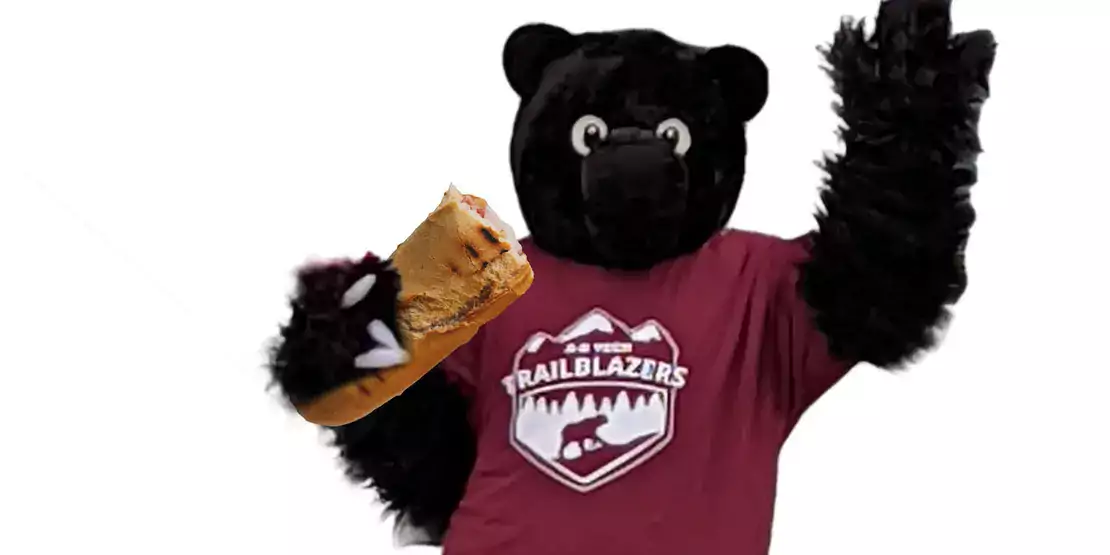 Trailblazer Bear Mascot holding a sandwich in his right paw
