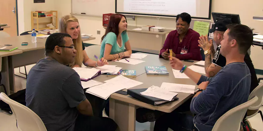 Group of people sitting around a table talking