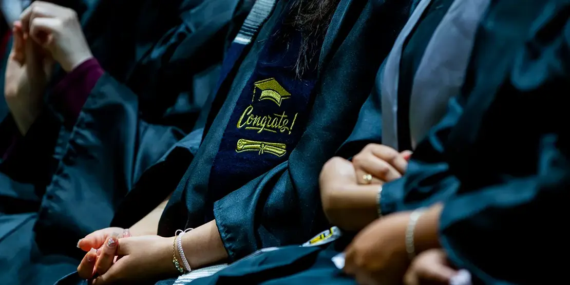 A-B Tech graduates listen as Gov. Josh Stein speaks inside Harrah's Cherokee Center during the university's graduation ceremony, May 10, 2025, in Asheville.