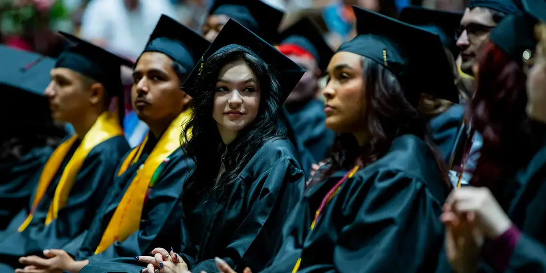 A-B Tech graduates listen as Gov. Josh Stein speaks inside Harrah's Cherokee Center during the university's graduation ceremony, May 10, 2025, in Asheville.