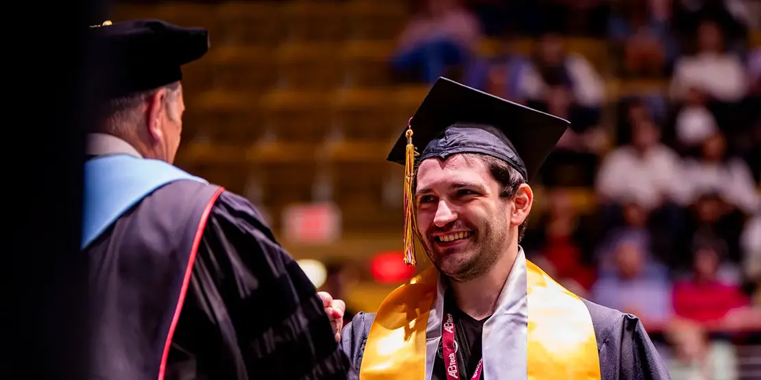 A-B Tech President Dr. John D. Gossett presents graduates with their diplomas inside Harrah's Cherokee Center during the university's graduation ceremony, May 10, 2025, in Asheville.
