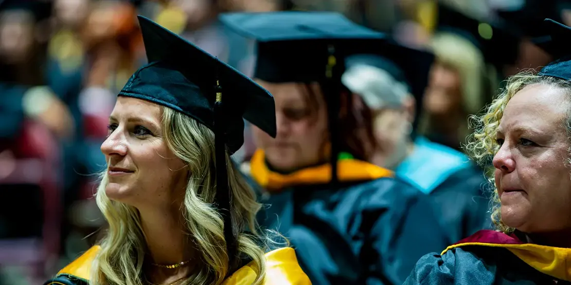 Graduates listen as A-B Tech President Dr. John D. Gossett speaks inside Harrah's Cherokee Center during the university's graduation ceremony, May 10, 2025, in Asheville.