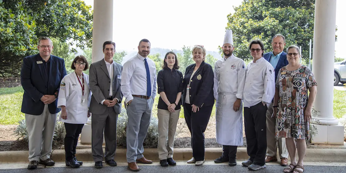 10 men and women standing outside under a portico